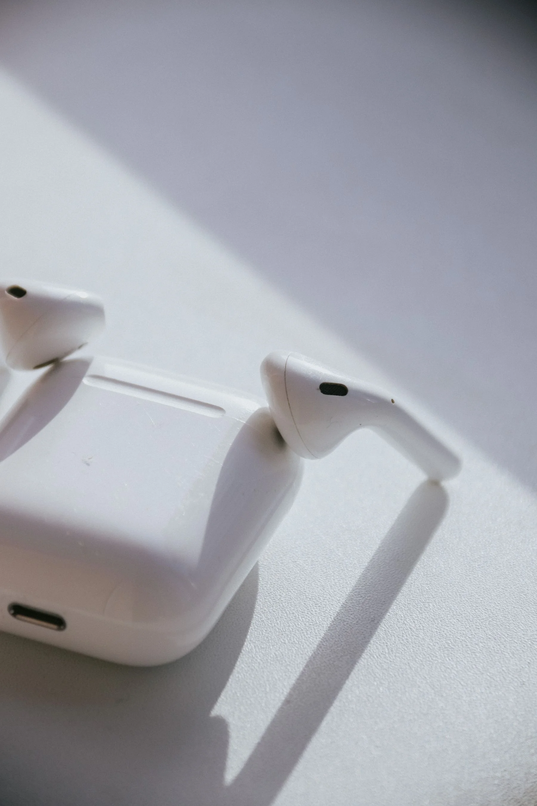 White wireless earbuds resting on a charging case