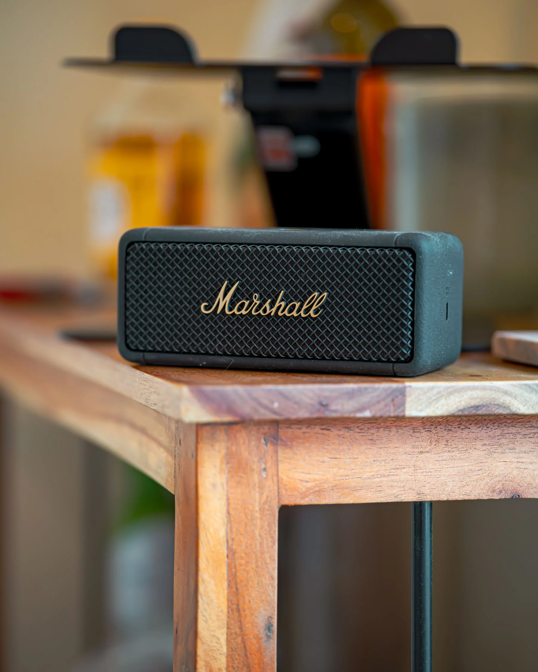 A compact portable speaker on a wooden table